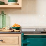 Contemporary Classics Antique White square wall tiles behind a green Everhot range cooker