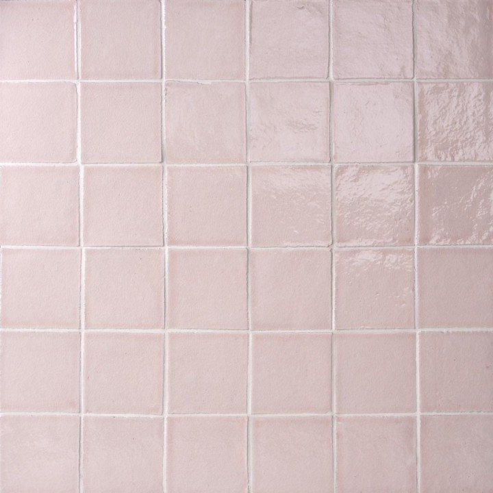 Wall of blush pink handmade square tiles with white grout