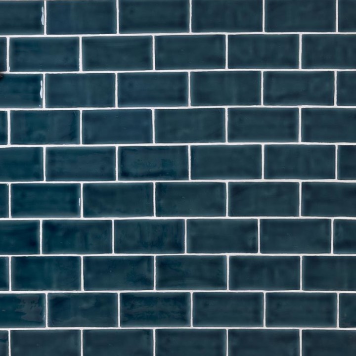 Wall of a deep navy medium brick metro tiles with white grout laid in a brick bond tile pattern