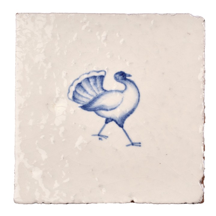 Cut out image of white tile with handpainted delft blue bustard illustration