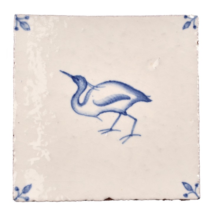 Cut out image of white tile with handpainted delft Egret bird illustration and ornate corners