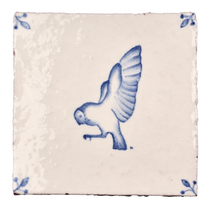 Cut out image of white tile with handpainted delft owl illustration and ornate corners