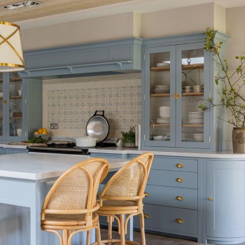 Handpainted Ana flax blue wall tiles behind a range cooker