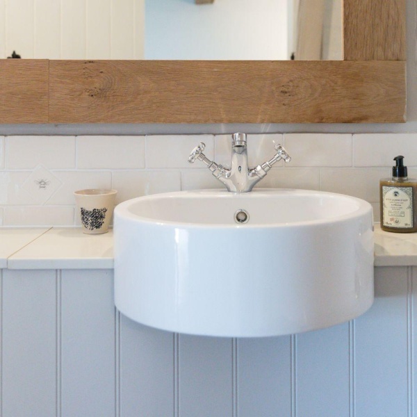 Hand painted insect tacos or small tiles in a backsplash behind a bathroom sink