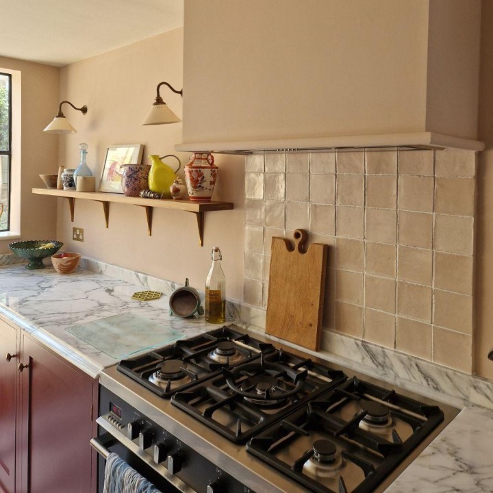 Isles Uist off-white handmade square wall tiles on the wall behind a range cooker