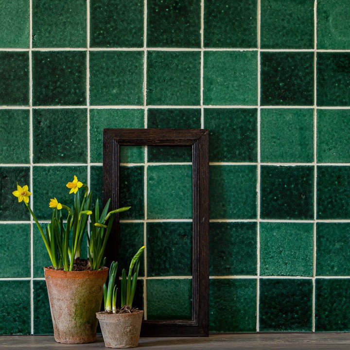 Isles Iona 11cm x 11cm Square Tiles on wall with potted daffodils in front