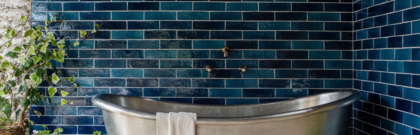 Zellige stoneware effect handmade Isles  skinny brick wall tiles in Islay, on the wall around a silver tin bath.
