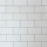 Wall of chalk white large metro tile finished with medium grey grout laid in a brick bond pattern