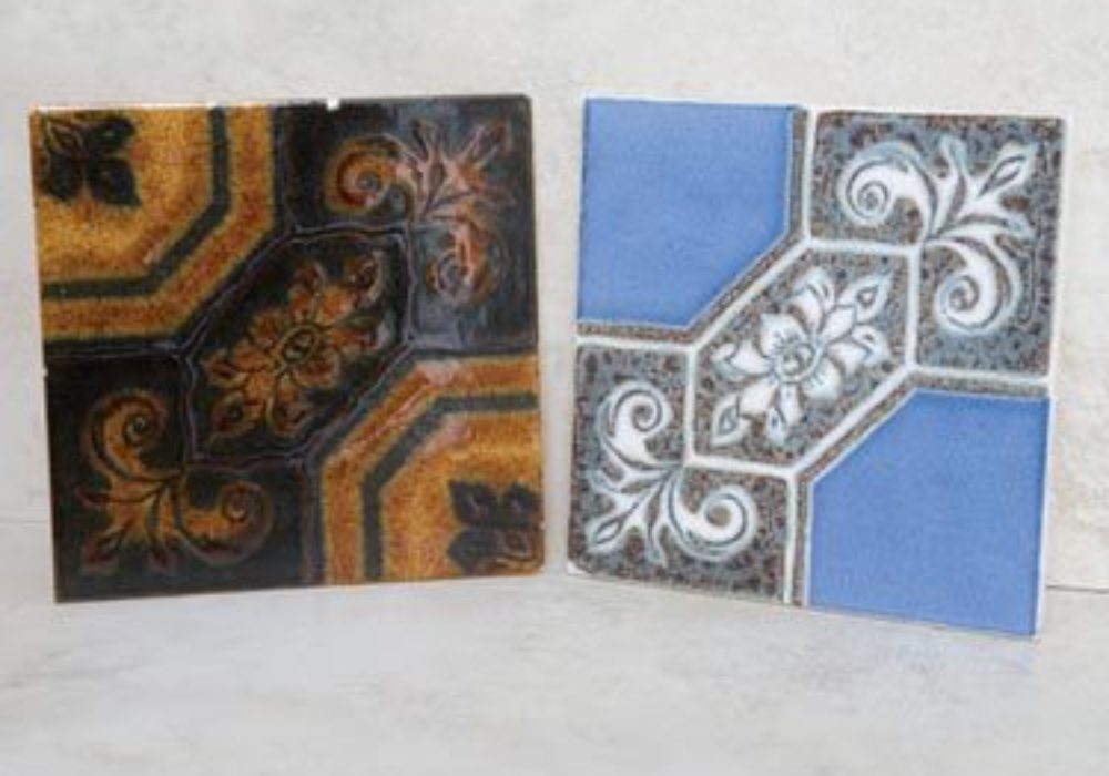 Two geometric pattern tiles created in the 1970s. One in orange and brown and the other in blue and grey with an ornate pattern.