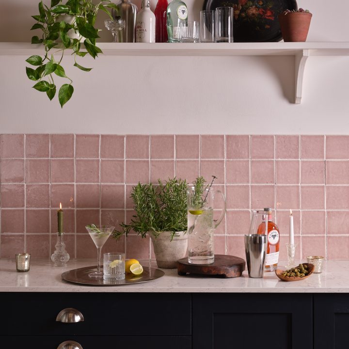A classic navy blue kitchen paired with our Halycon blush square tiles in Wild Rose, arranged in a grid pattern and finished with white grout.
