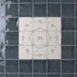 Panel of 9 square tiles with delft illustration of cherups framed with blue square tiles with medium grout