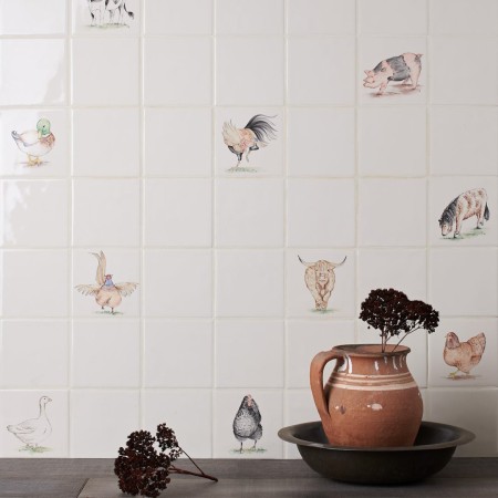 Wall of hand painted animal square tiles paired with plain tiles cockerels, highland cows, pigs and horses
