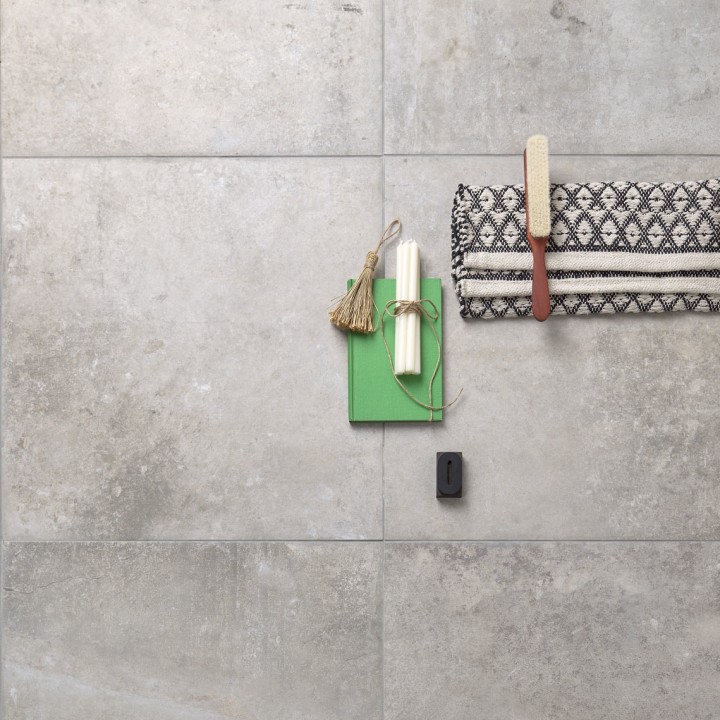 Floor of rectangle concrete effect porcelain floor tiles with grey grout with home accessories on top