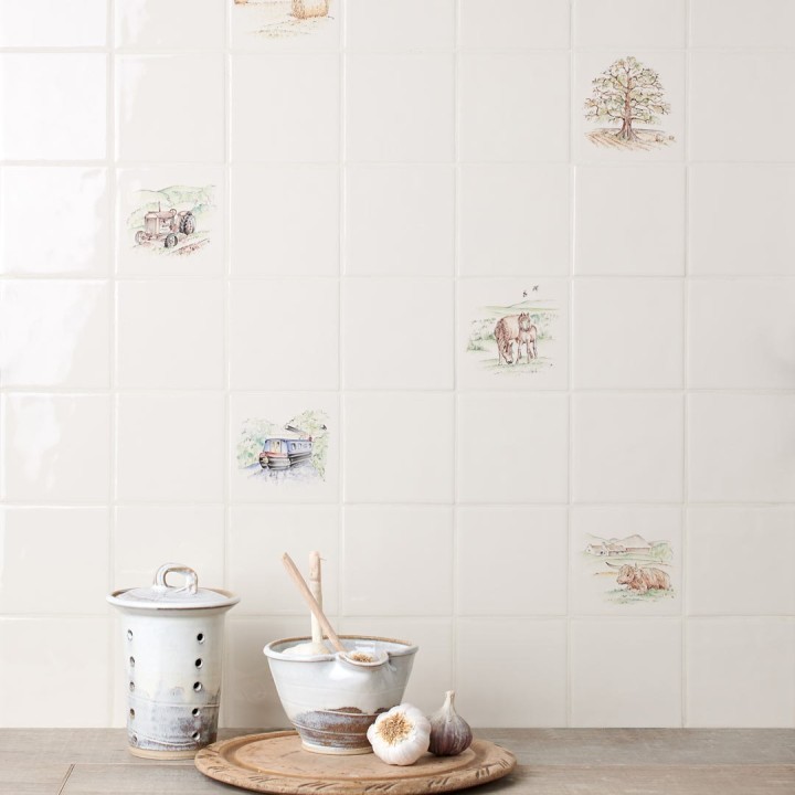 Wall of hand painted countryside farming and scenes square tile with an ivory background against kitchen accessories