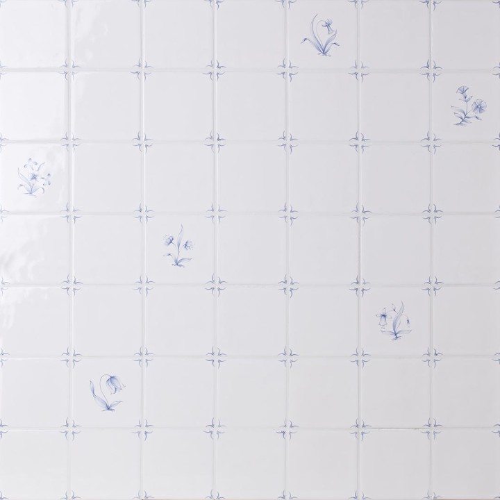 Wall of delft flower square tiles mixed with plain delft tiles in the classic blue style with white grout