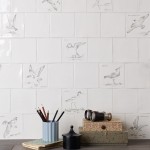 Wall of hand painted coastal bird square tiles in a charcoal style with an antique background paired with plain antique white tiles