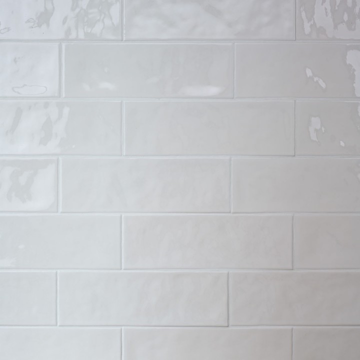 Wall of long white brick tiles with white grout