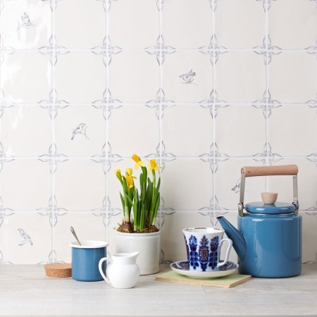 Wall of delft bird square tiles mixed with plain delft tiles in the classic blue style behind home accessories