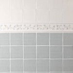 Wall of square tiled halfway with Emma flax blue pattern brick and taco tiles as a border, finished with half rounds.