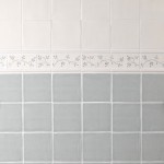 Wall of square tiled halfway with Emma flax blue pattern brick and taco tiles as a border, finished with half rounds.