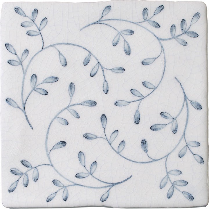 Cut out image of a crackle glazed tile with hand painted intricate leaf pattern in blue