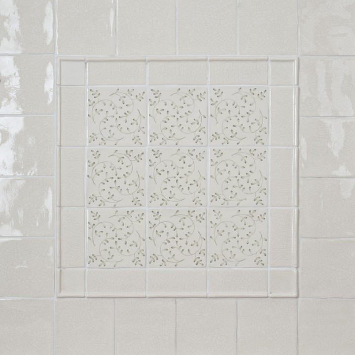 Wall of Emma Sage Green leaf Pattern Square tiles framed with half rounds and surrounded with Emma Sage Green Plain Square tiles
