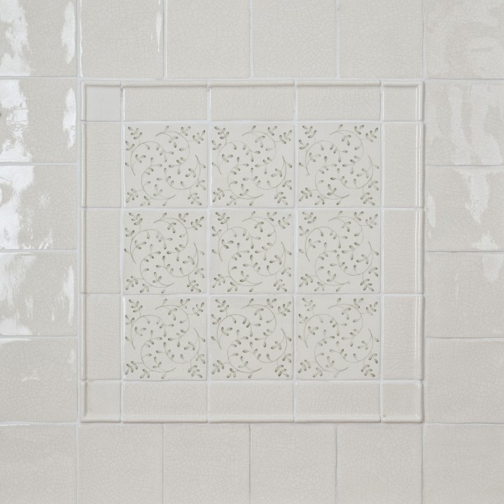 Wall of Emma Sage Green leaf Pattern Square tiles framed with half rounds and surrounded with Emma Sage Green Plain Square tiles