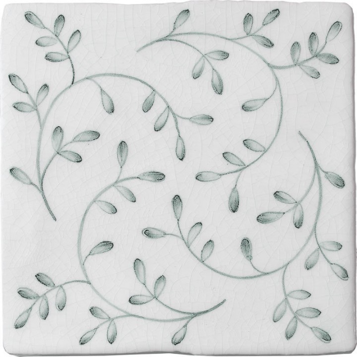 Cut out image of a crackle glazed tile with hand painted intricate leaf pattern in green