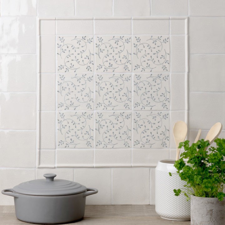 Flax Blue Pattern Square tiles wall panel, framed with half rounds and paired with Emma Flax Blue Plain Square tiles and border tiles behind a kitchen worktop