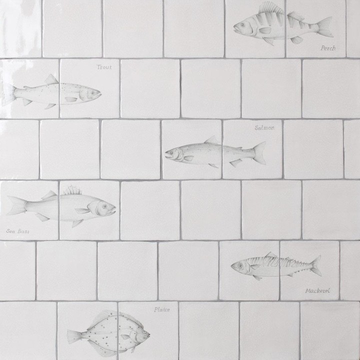 Wall of antique white tiles and fish tiles hand painted with fish motifs with medium grey grout