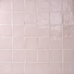 Wall of blush pink handmade square tiles with white grout