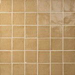 Wall of saffron yellow handmade square tiles with jasmine grout