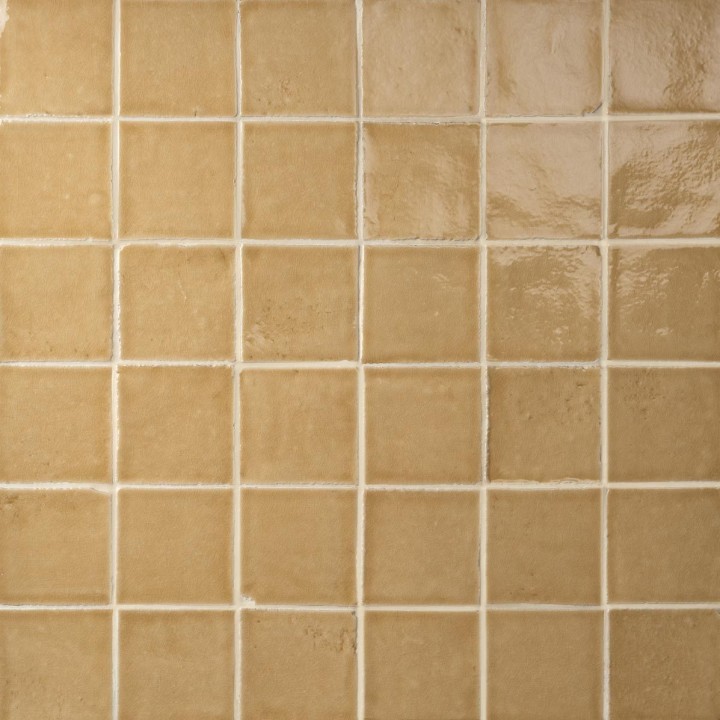 Wall of saffron yellow handmade square tiles with jasmine grout