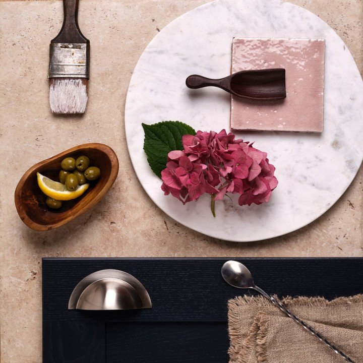 Flatlay of a Porcelain stone floor beneath a navy kitchen cabinet door and a rose pink square tile