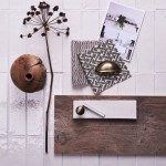 Flatlay of skinny chalk white tiles with white grout in the background and kitchen hardware and accessories on top.