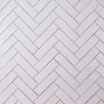 Wall of skinny warm white tiles with limestone grout laid in herringbone pattern