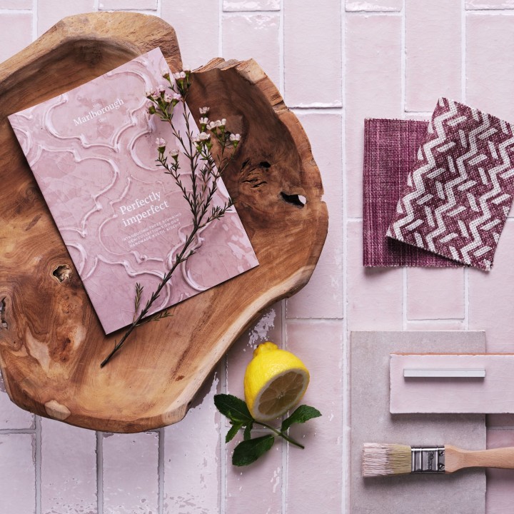 Flatlay of skinny blossom pink tiles with white grout in the background and kitchen hardware, fabric swatches and accessories on top.