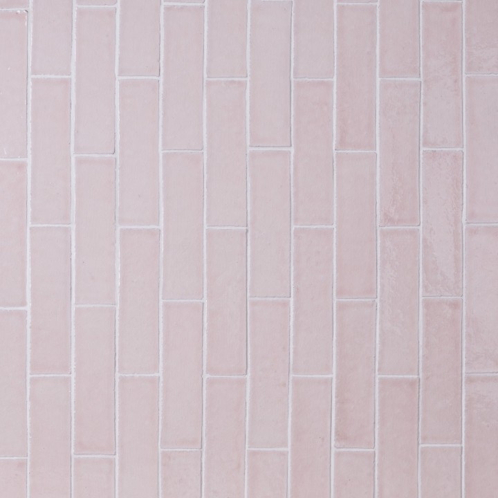 Wall of skinny pale grey tiles with white grout laid in a vertical brick bond pattern
