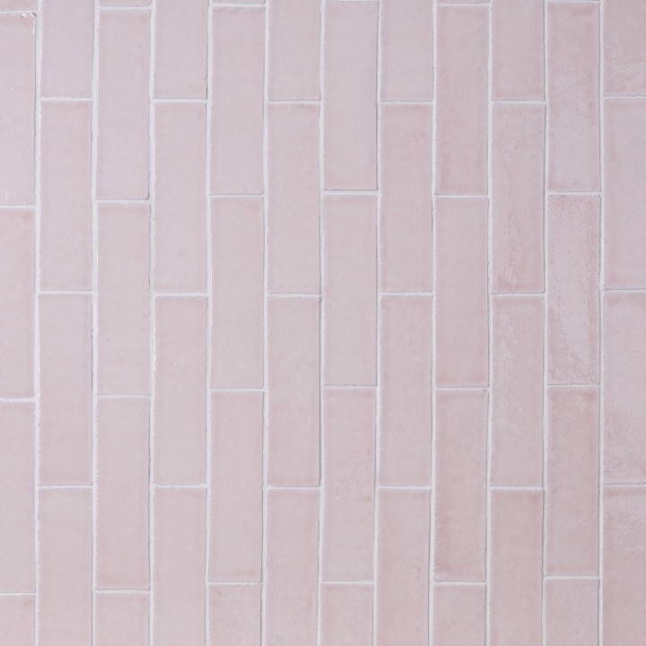 Wall of skinny pale grey tiles with white grout laid in a vertical brick bond pattern