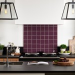 Kitchen with a cooker splashback of dark plum burgundy gloss square tiles with a kitchen island in front