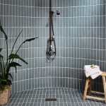 Curved shower tiled with a teal blue green skinny metro matt tile with a chrome shower moving onto wood.