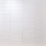 Wall of white skinny metro matt tiles with white grout stacked in a horizontal tile pattern