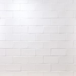 Wall of white matt metro tiles with white grout laid in a brick bond tile pattern