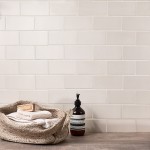 Wall of neutral warm white matt metro tiles with jasmine grout styled with bathroom accessories and toiletries