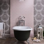 A free standing bath with a strip of blush pink metro matt tiles paired with the farrow and ball lotus wallpaper and an oak effect floor tile