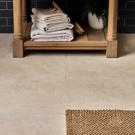 Sandstone porcelain floor tile across a floor with a jute bathmat paired with a matt tile and vanity unit