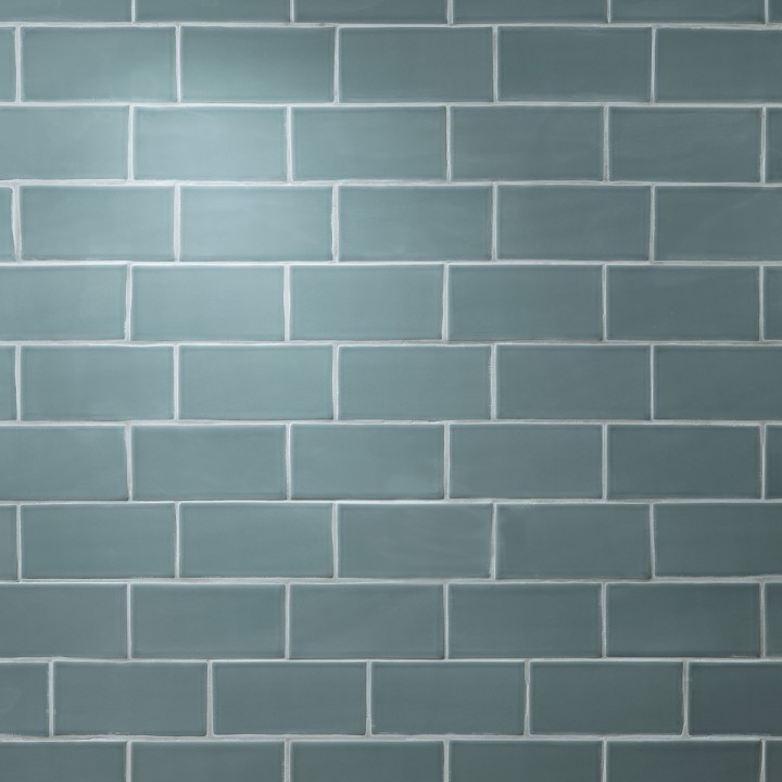 Wall of teal blue green matt metro tile laid in a brick bond tile pattern