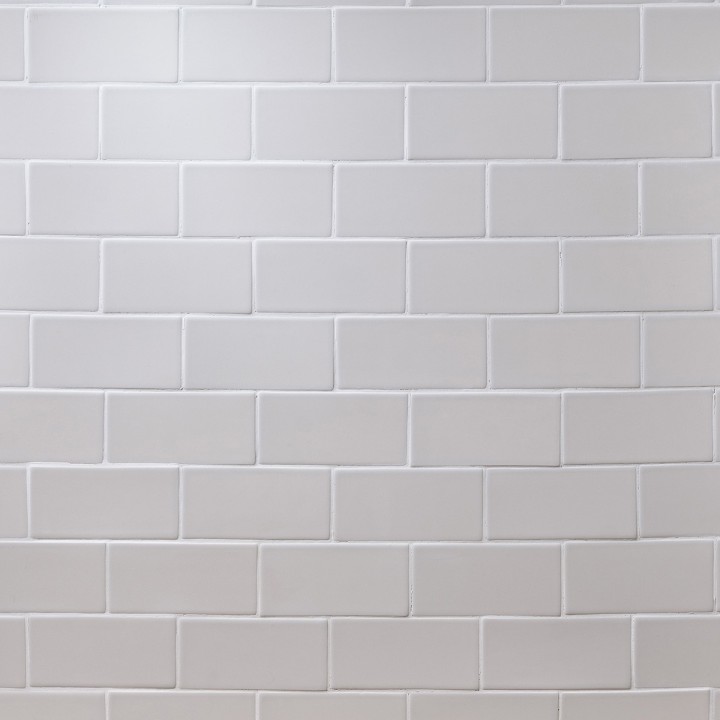 Wall of sky white metro matt tiles with white grout laid in a brick pond tile pattern