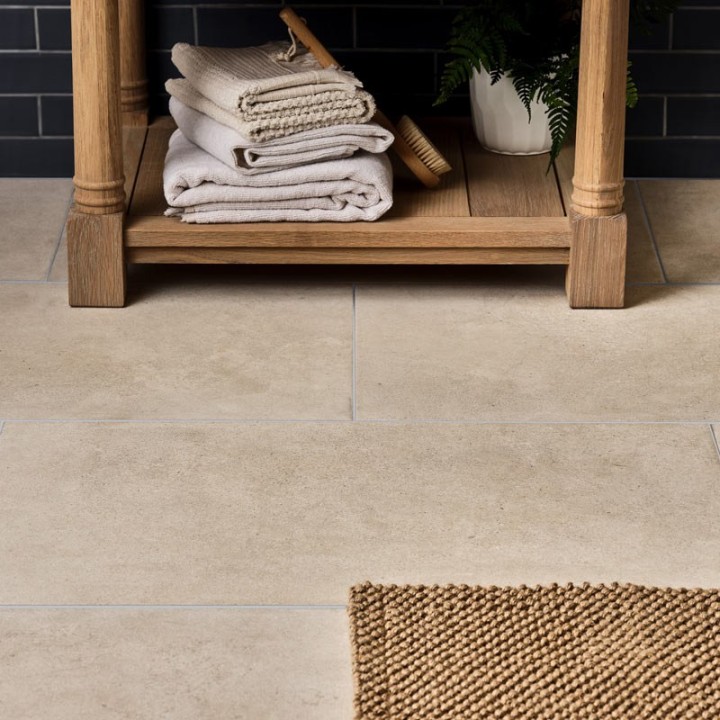 Sandstone porcelain floor tile across a floor with a jute bathmat paired with a matt tile and vanity unit