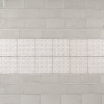 Wall of beige metro tiles with a strip of pendragon pattern tiles